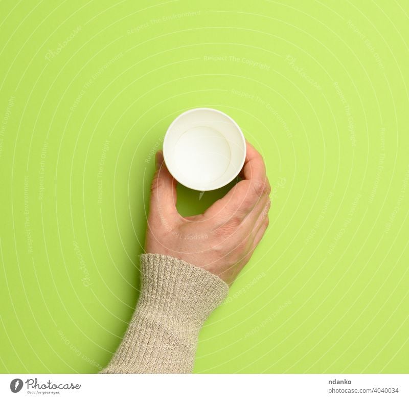 female hand holding empty paper disposable cup on green background coffee container dishware drink caucasian arm beverage blank breakfast cappuccino cardboard