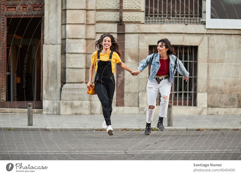 Two teenager girls running down street. madrid young people friendship lifestyle beautiful fun happy together leisure woman smiling teens cheerful female youth