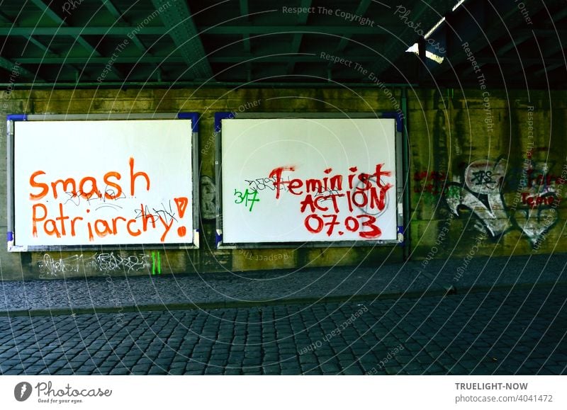 Women's Day! Excited young women in wild rage used the will-less surrender of innocent white billboard walls for blood-red angry battle slogans. Feminist Action 07.03 and Smash Patriarchy!