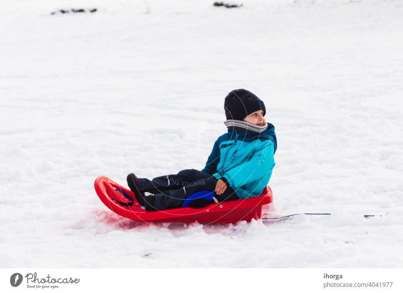 boy with red sled in the snow Winter active child childhood cold fun funny happiness happy hat holiday kids knitted leisure little mountain natural nature