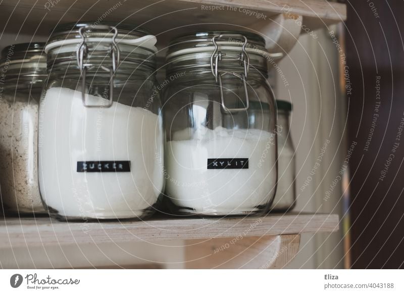 Sugar and xylitol in storage jars on the kitchen shelf. Xylitol sugar substitute Sugar alternative Kitchen storage glass Preserving jar salubriously Labeled