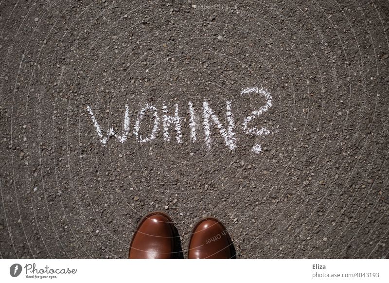 A person stands in front of the question "where to?" written on the floor with chalk Whereto Road marking Orientation Direction Navigation Perplexed Future