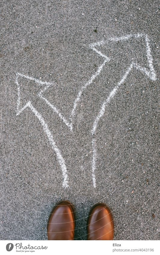 A person stands in front of arrows pointing in different directions. Decision making. Decide Arrow Direction Future decision making off Orientation Road marking