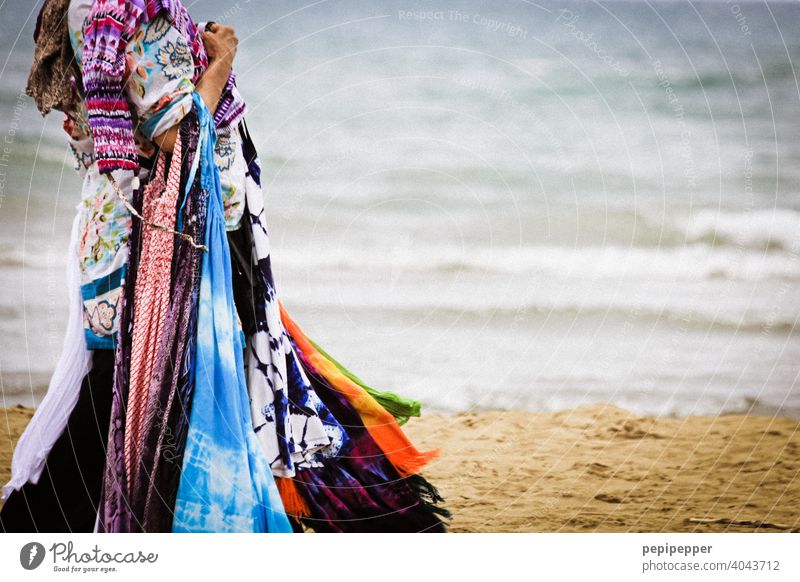 Woman selling scarves and summer dresses on the beach on vacation Beach Sell sale Shopping Trade Colour photo Business Fashion Commerce Customer consumer