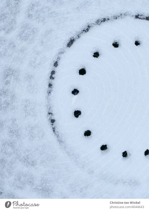 Manhole cover and paving stones covered with snow. The edge and holes of the manhole cover are free of snow. Snow Winter Paving stone Lanes & trails