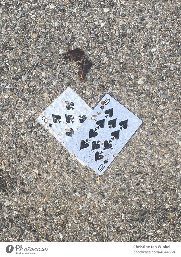 unhealthy | gambling addiction...  Two lost or discarded dirty playing cards lie on the grey asphalt Playing Cards Unhealthy Compulsive gambling frowzy Ground