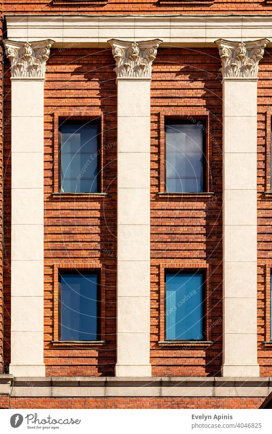 Orange brick façade with cream white three art nouveau columns and four blue windows during sunny day at Riga Old Town, Latvia, Europe building art-nouveau old