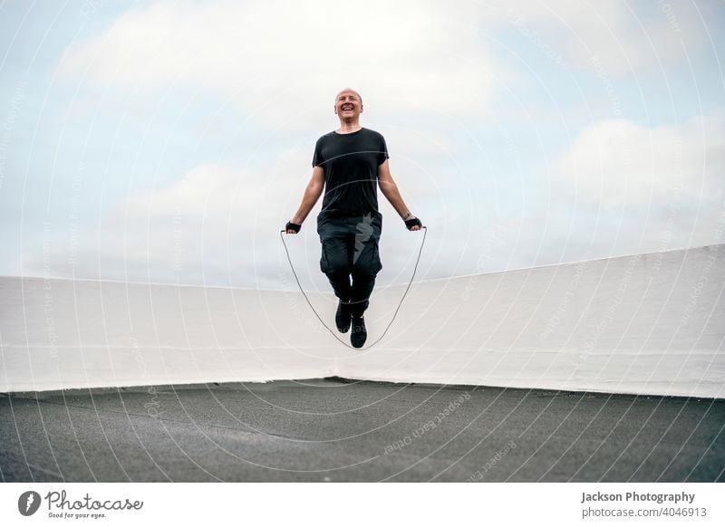 A man exercising on the rooftop using jumping rope during the lockdown sport pandemic skipping rope cardio endurance copy space outdoors person active activity