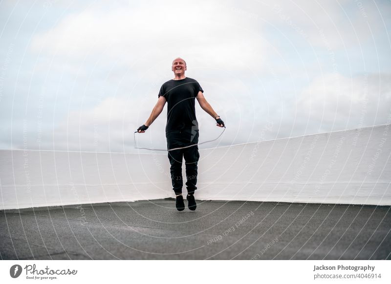 A man exercising on the rooftop using jumping rope during the lockdown sport pandemic skipping rope cardio endurance copy space outdoors person active activity