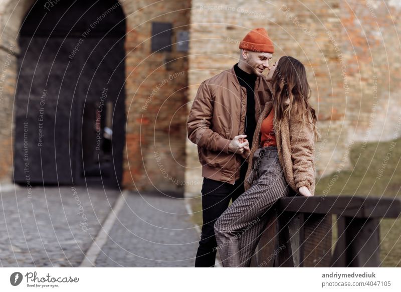 Beautiful Tourist Couple In Love Walking On Street Together. Happy Young Man And Smiling Woman Walking Around Old Town Streets, Looking At Architecture. Travel Concept.