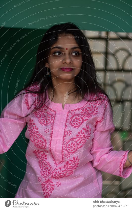 Indian teenage girl in pink dress standing on rooftop staircase asian conservative brunette hair black hair attractive young smile household background urban