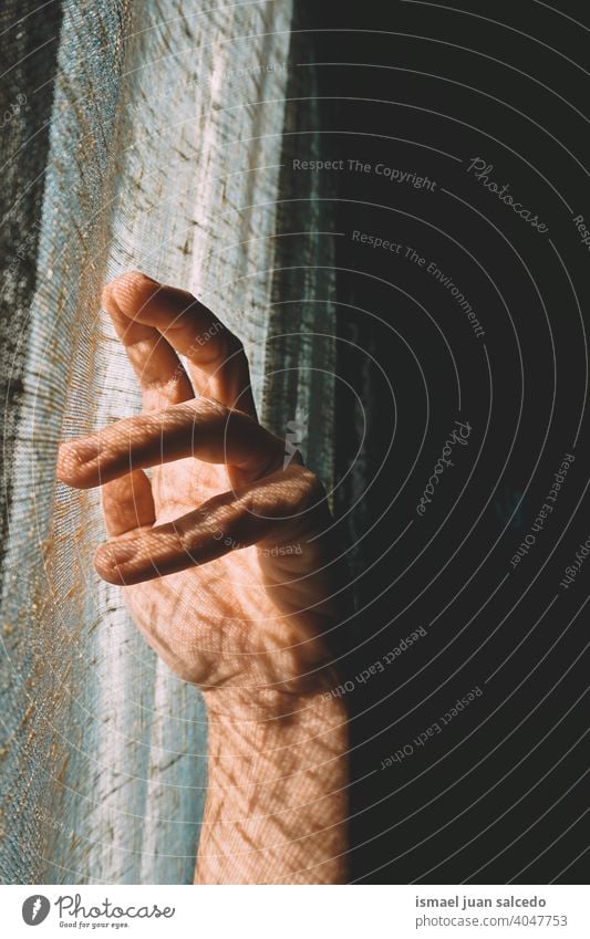 man hand gesturing in the shadows light sunlight silhouette fingers palm body part wrist arm skin person gesture concept symbol minimal minimalism background