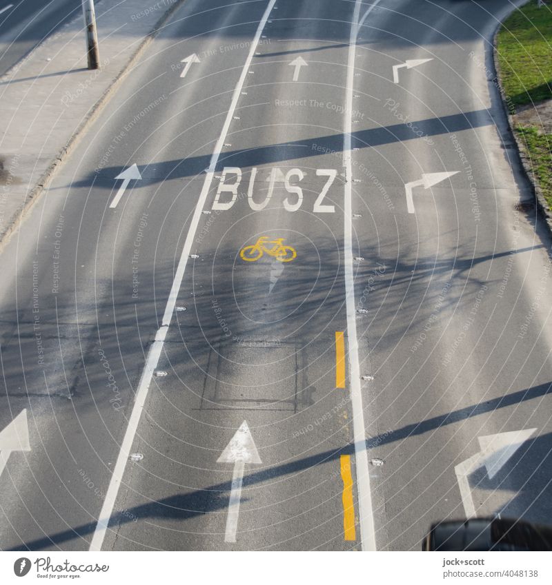 Bus lane and bike lane in Budapest Street Traffic infrastructure Lane markings Traffic lane bus lane wheel track Sunlight Shadow play Traffic arrow sign