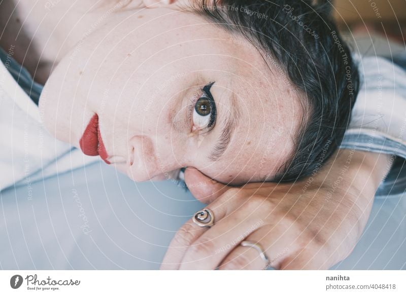 Portrait of a young woman leaning her face against a cold glass table depression blue sad mental health psychology sadness depressive white reflection mirror