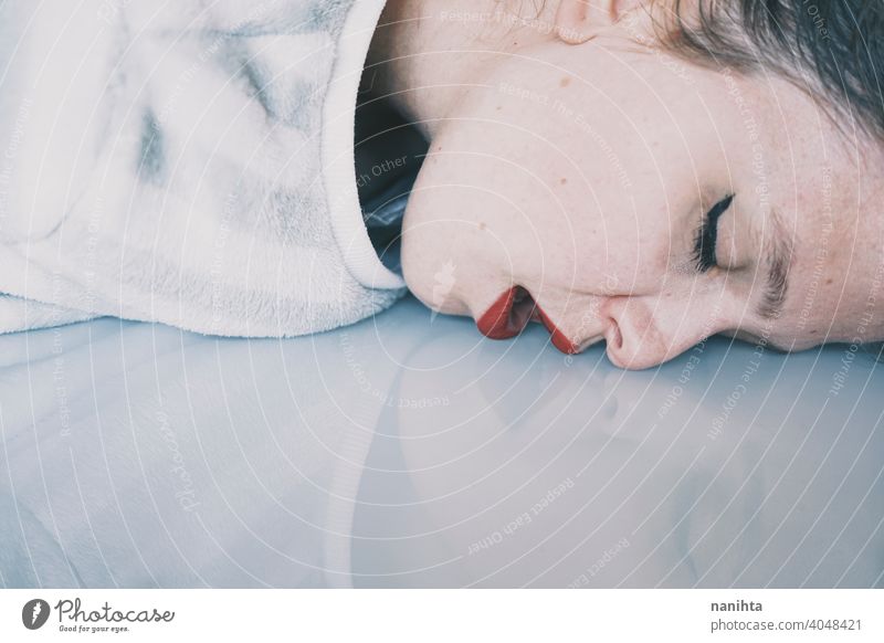 Portrait of a young woman leaning her face against a cold glass table depression blue sad mental health psychology sadness depressive white reflection mirror