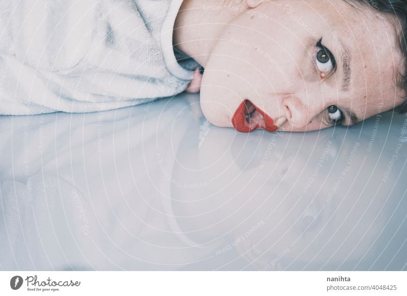 Portrait of a young woman leaning her face against a cold glass table depression blue sad mental health psychology sadness depressive white reflection mirror