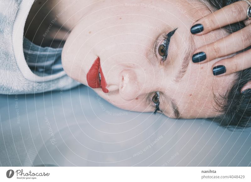 Portrait of a young woman leaning her face against a cold glass table depression blue sad mental health psychology sadness depressive white reflection mirror