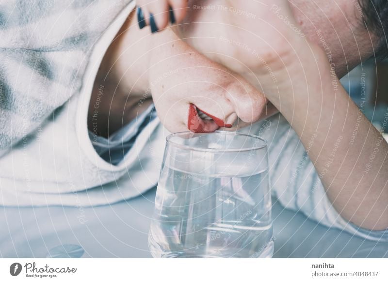 Portrait of a young woman hidden by a glass with a transparent drink depression blue sad mental health psychology sadness depressive cold white reflection