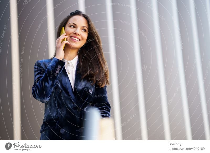 Business woman wearing blue suit using smartphone in an office building. businesswoman girl person device lifestyle female urban background lady elegant outside