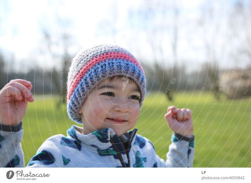 smiling happy small child holding his hands up Looking away Upper body Dependability Exterior shot Multicoloured Help Love Together Safety (feeling of)