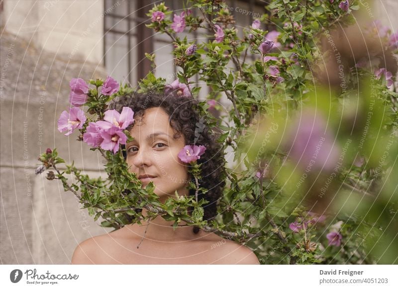 Beauty headshot of a young brunette woman with pink flowers outdoors. Shot on 35mm analog cine film. posing model person beautiful beauty fresh care skincare