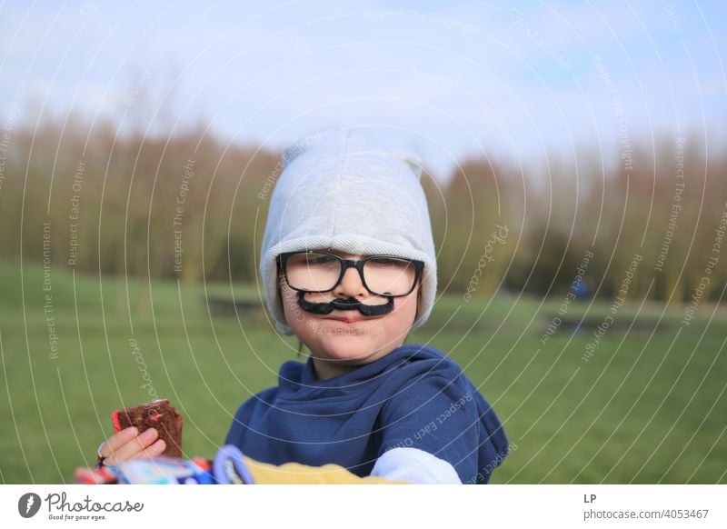 small child wearing glsses, a hat and a fake moustache Looking Portrait photograph Multicoloured Mysterious Emotions Funny Moustache Fashion Face