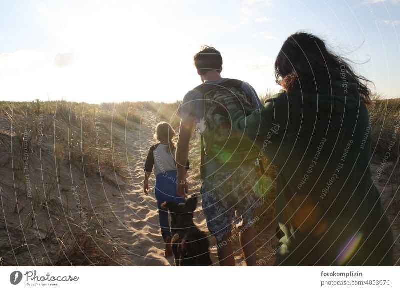 Young people with child and dog on the way over the dune to the beach sand dune Walk on the beach duene Summer vacation Vacation & Travel family vacation