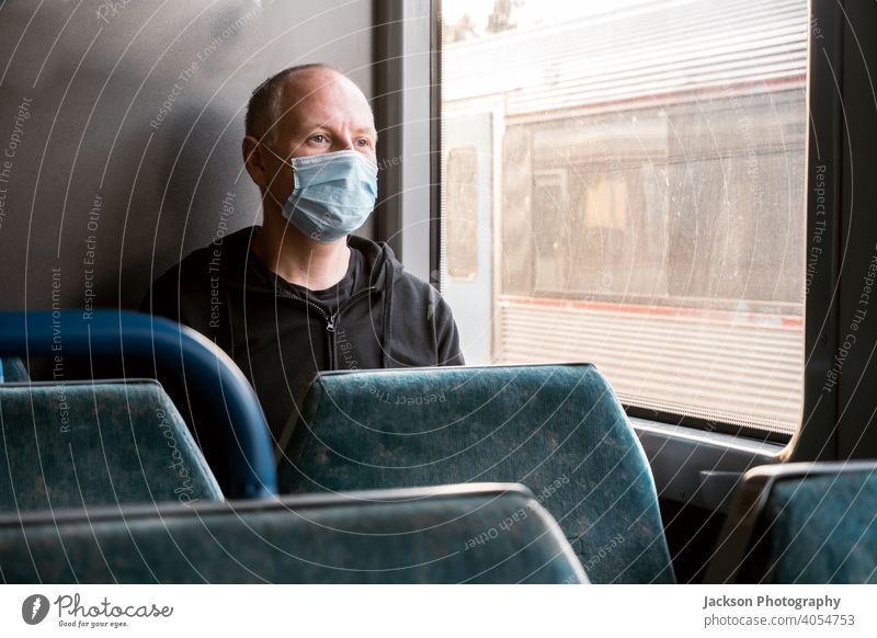 A man wearing surgical mask looking through the window in a train pandemic serious sad copy space public transport covid19 male caucasian corona virus lockdown