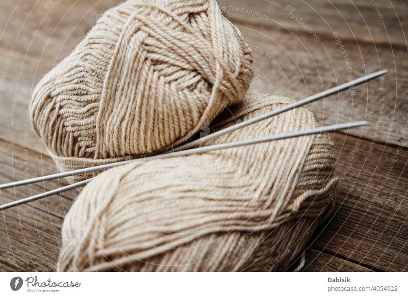 Two skeins of woolen yarn and needles for knitting on a wooden background needlework handmade hobby thread craft material warm soft fashion textile homemade