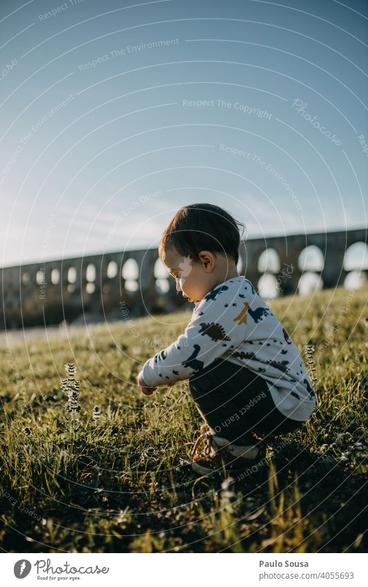 Side view child playing outdoors Child childhood 1 - 3 years Caucasian explore Authentic Spring Spring flower Happiness Toddler Happy Infancy Exterior shot