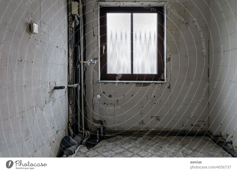 Refurbishment: Old bathroom with window, socket, pipes and drainage, but without tiles, floor or heating Renovation refurbishment Construction site Window Room