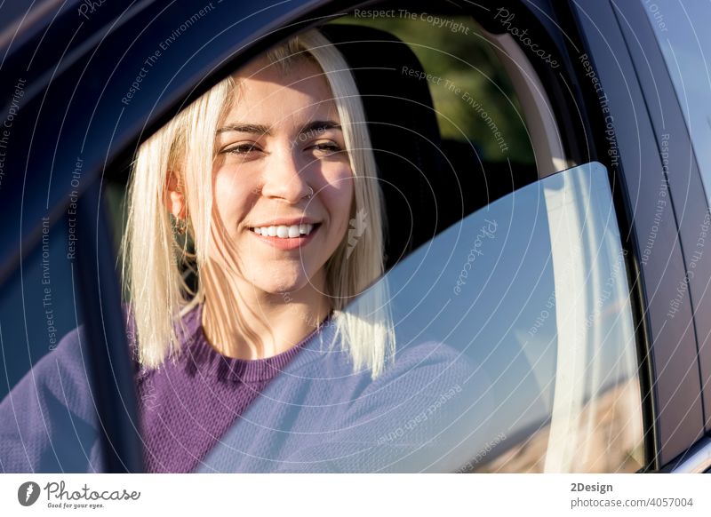 Young smiling woman steering car at sunset person hire hiring insurance owner safety successful test driver happiness joyful leasing looking pleasure purchase