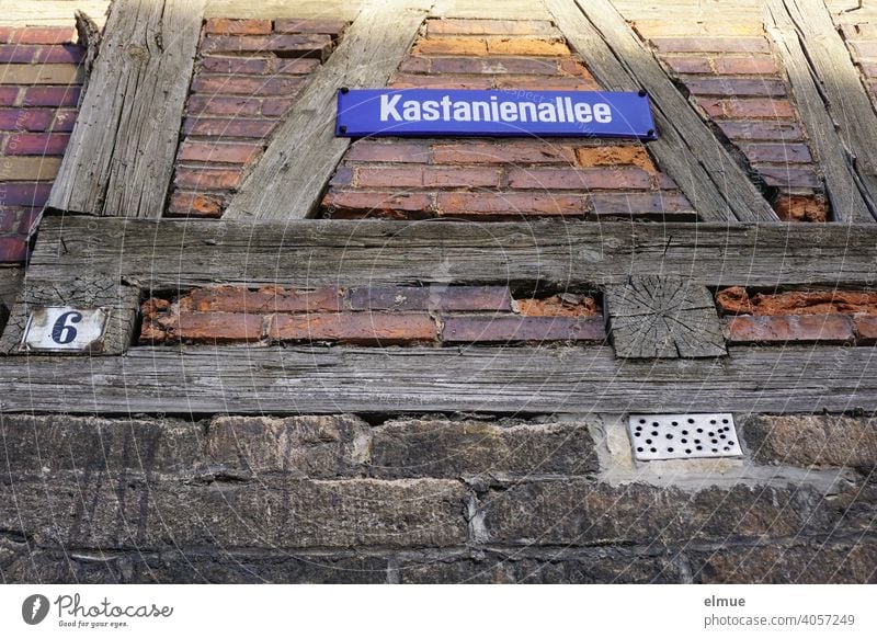 At an old half-timbered house there is a street sign "Kastanienallee" and a sign with the house number 6 / rural living / frog perspective Half-timbered house