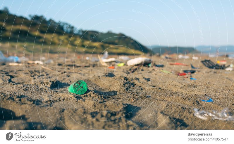 Dirty beach landscape full of waste trash garbage plastic sand dirty contaminated environment nature pollution coast plastic lid rubbish problem environmental