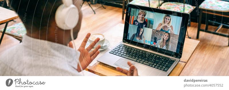 Man talking on video call with friends from a cafeteria unrecognizable man coffee shop internet laptop headphones banner web panoramic panorama online person