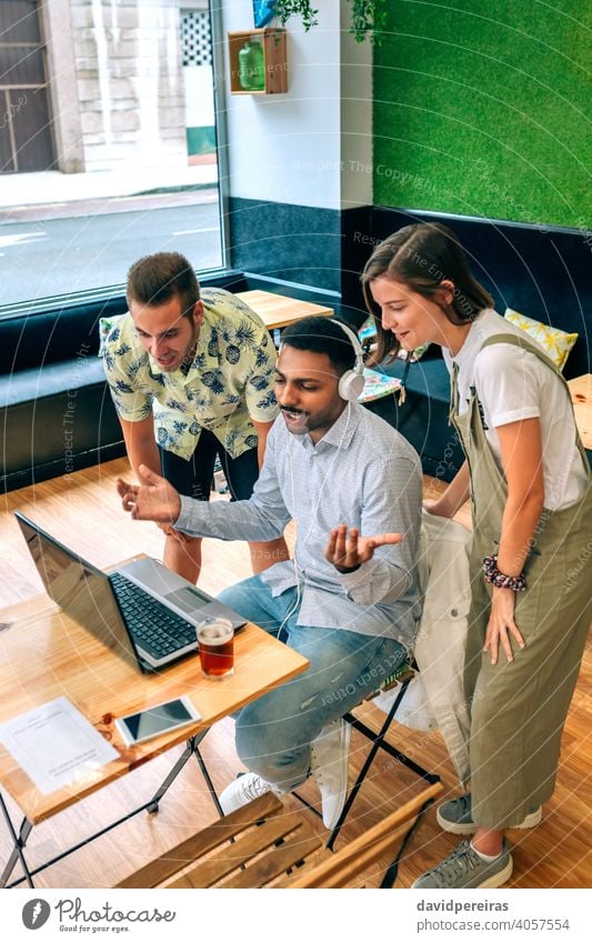 Group of friends talking on videoconference from coffee shop group laptop smiling cafeteria headphones cheerful black man person male people video call drink