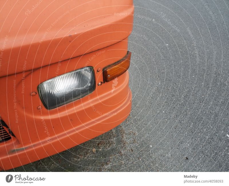 American parcel car converted to a camper and painted orange in Oerlinghausen near Bielefeld on the Hermannsweg in the Teutoburger Forest in East Westphalia-Lippe