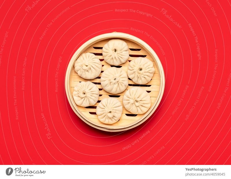 Raw baozi dumplings in a bamboo steamer, top view.  Cooking Chinese steamed dumplings above view asian bao dumplings bun chinese chinese food colored background