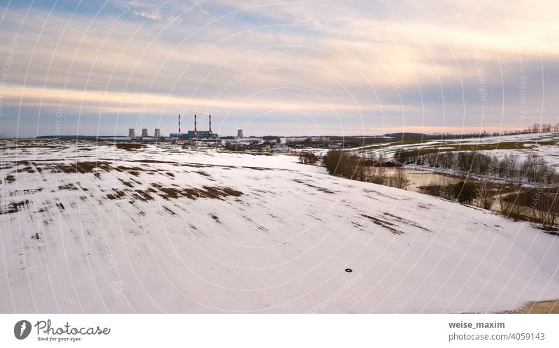 Aerial view of power station in evening light. Early spring urban industrial landscape. Snow melting, Season change industry factory environment plant pollution