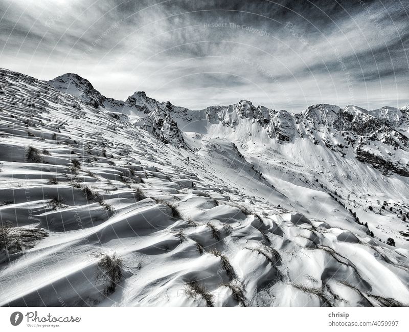 windswept landscape Winter mood Wind Snowscape Snowcapped peak snow drifts Shadow white Tuft of grass Clouds Snapshot