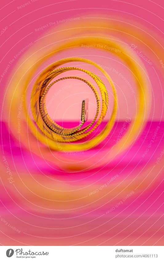 Macro shot of rolled up yellow tape measure on pink background Studio shot Studio lighting Pink Yellow Tape measure Coil meter tape Band Rollup Diet decrease