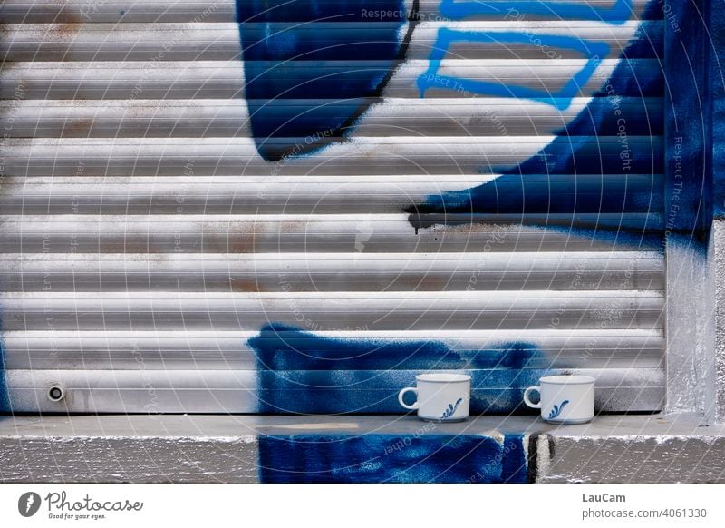 Two cups on a windowsill in front of closed shutter with silver-blue graffiti Window Roller shutter Roller blind Graffiti Cup White Blue Silver Coffee