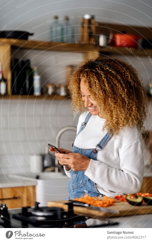 Woman texting with her smartphone. middle age couple love cooking home cozy caucasian relationship preparing female happy person stove kitchen woman alone