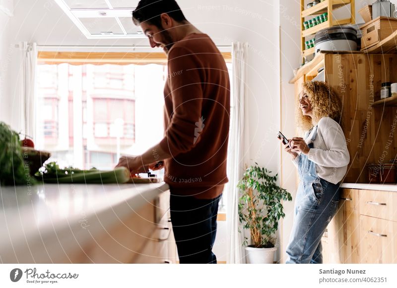 Couple laughing and standing in kitchen. middle age couple love cooking home cozy caucasian relationship preparing female happy person stove woman beautiful