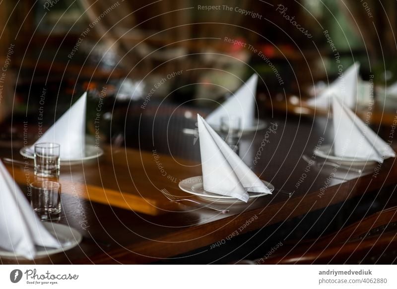 beautifully served table in a restaurant. selective focus. noise is present silverware set napkin luxury glass empty dish cutlery celebration service dinner