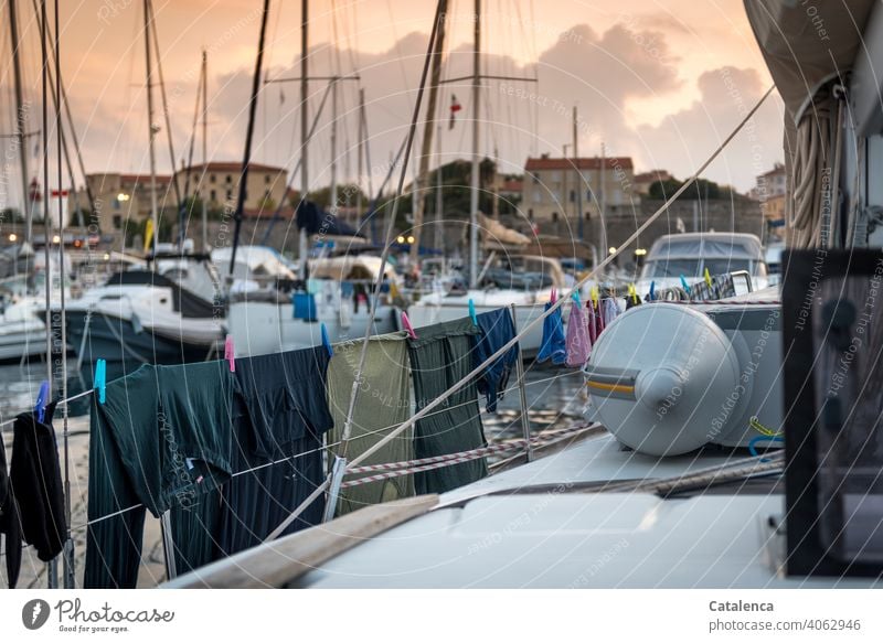 Washing day, laundry hanging to dry on the railing of a sailing yacht in the marina, in the background buildings Railing Laundry Dry masts sailboats clothesline