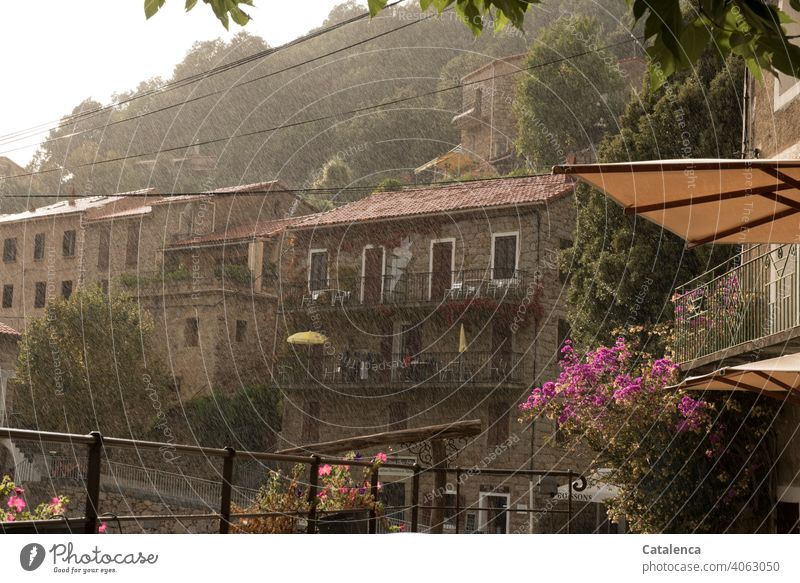 A refreshing rain shower descends on the village on the mountain daylight Day mountains Roof Architecture Village Building houses Tree Clouds Sky Sunshade