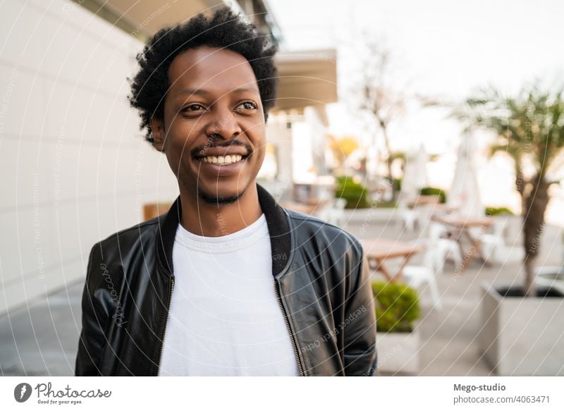 Portrait of afro man standing outdoors. tourist traveler suitcase destination concept travelling holiday joy enjoy adventure traveller walk vacations portrait