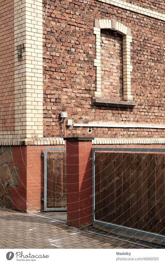 Residential house with bricked up window and facade from old brick two colors in the summer with sunshine in Wettenberg Krofdorf-Gleiberg with pouring in Hessen