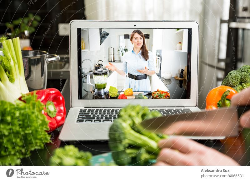 Beautiful happy woman streaming broadcast video blog about tasty and healthy food from home kitchen. Healthy lifestyle and social media. Man watching video recipe on laptop and cooking at home.